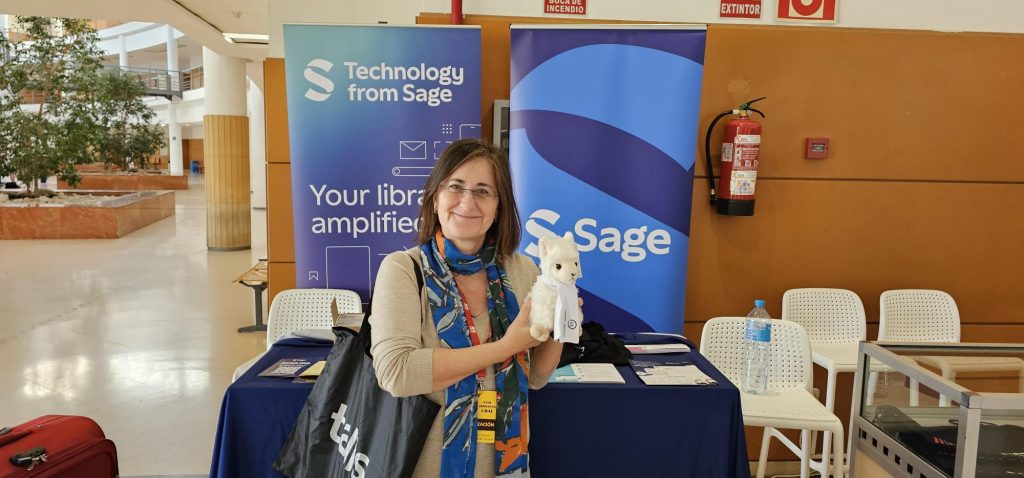 Lean Library Llama being held by Juana at the Technology from Sage stand at REBIUN Assamblea